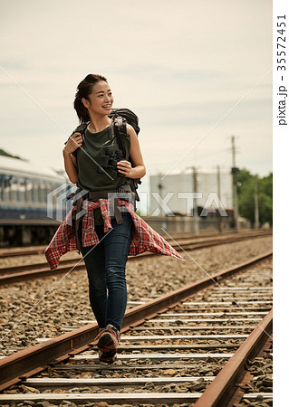 線路 廃線を行く女性バックパッカーの写真素材