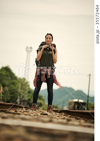 線路 廃線を行く女性バックパッカー ポートレートの写真素材