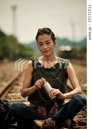 線路　廃線を行く女性バックパッカー　ポートレート 35572511