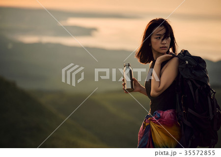 草原を行く女性バックパッカーの写真素材