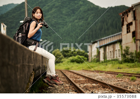 女性バックパッカー 駅 ホームの写真素材