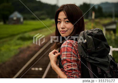 女性バックパッカー 駅 ホーム ポートレートの写真素材