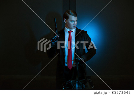 Man is a murderer with a gun in his hand. 35573645