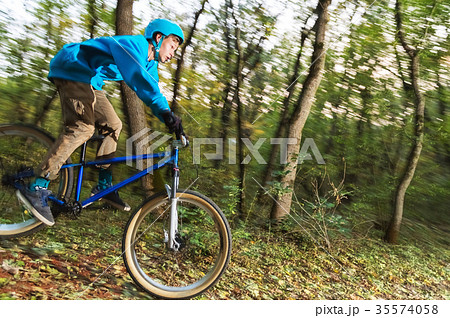 a young guy in a helmet flies landed on a bicycle 35574058