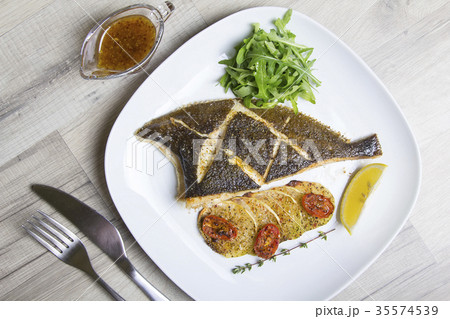 Fried flounder with zucchini, tomatoes and arugula 35574539