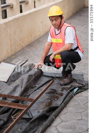 construction worker inspecting raw material pile construction worker inspecting raw material pile 35575994