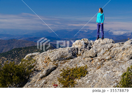 Young woman standing on rocky top of the mountain 35578879