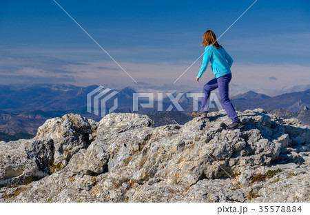 Young woman walking on rocky top of the mountain 35578884