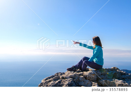 Woman sitting in a rocky top of the mountain 35578893