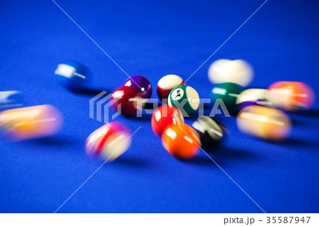blurry and moving of billiard balls in a blue pool 35587947