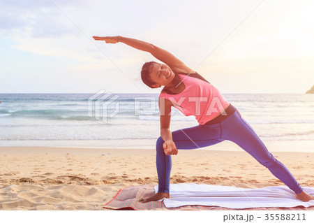 Woman playing Yoga and exercise on the tropical beach in Thailand Woman playing Yoga and exercise on the tropical beach in Thailand 35588211