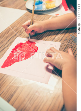 Happy asian girl painting red color on artwork wit Happy asian girl painting red color on artwork wit 35588443
