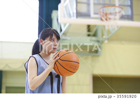 バスケをする女性 シュートの写真素材
