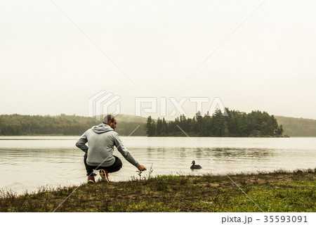 Man watching feeding ducks standing at lake of two 35593091