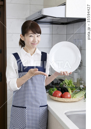 白い皿を持つエプロン姿の女性　　　　　　　　　 35594427