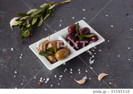 Black and green olives on a white plate 35595510