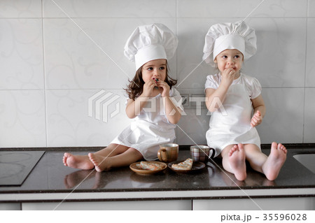 two little baker girls are drinking tea with a 35596028