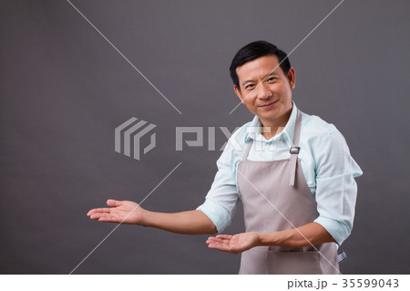 confident man shopkeeper pointing hand up to side 35599043