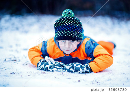Happy kid boy having fun with snow in winter 35603780