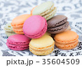 Colorful macaroons on a white lace background. 35604509