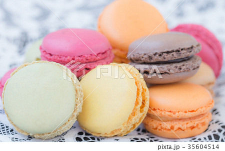 Colorful macaroons on a white lace background. 35604514