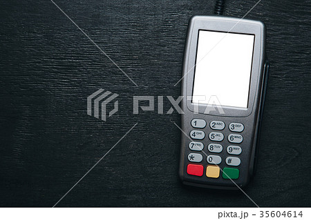 Credit card terminal on dark wooden desk 35604614