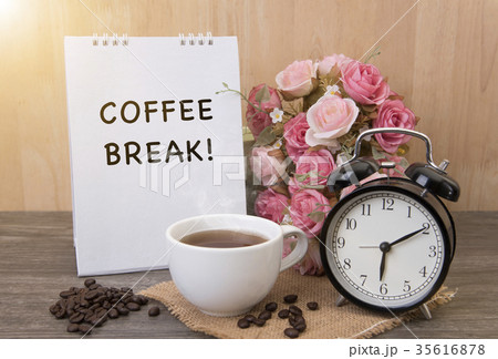 Hot cup of coffee and alarm clock on wood table 35616878