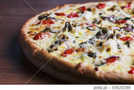 The fresh baked pizza with olives and tomatoes 35620286