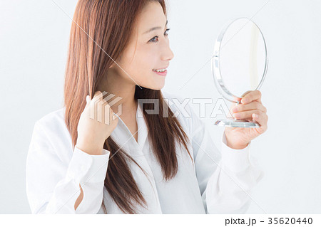 鏡で髪をチェックする女性 35620440