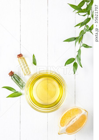 Lemon oil isolated on white wooden table Lemon oil isolated on white wooden table 35621707