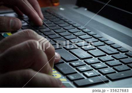 Men's hands are typing on the laptop's keyboard Men's hands are typing on the laptop's keyboard 35627683