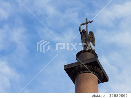Angel with cross against cloudy blue sky Angel with cross against cloudy blue sky 35629862