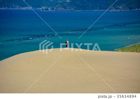 鳥取砂丘・丘の上からエメラルド色の海を眺める観光客がいる風景（１） 35634894