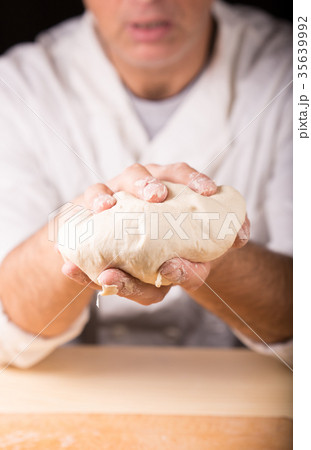 Baker holds raw dough in hands Baker holds raw dough in hands 35639992