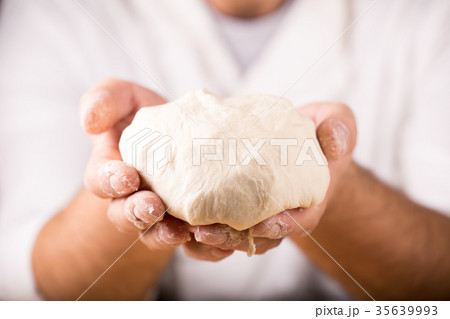 Baker holds raw dough in hands 35639993