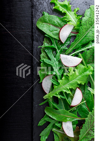Mixed salad leaves with radish on black slate 35641242