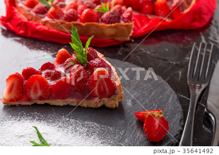 Strawberry pie on black slate plate. One piece 35641492