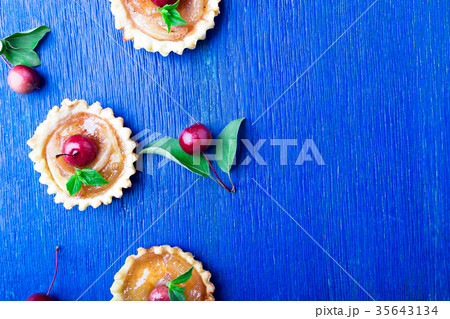 Apple caramel little tarts on blue rustic Apple caramel little tarts on blue rustic 35643134
