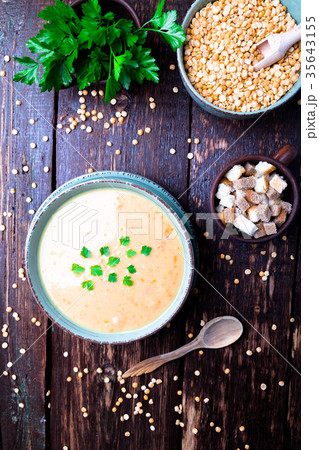 Pea soup in green bowl on brown wooden 35643155