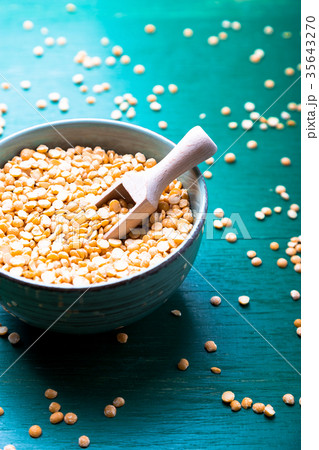 Dry yellow pea in green bowl on green Dry yellow pea in green bowl on green 35643270