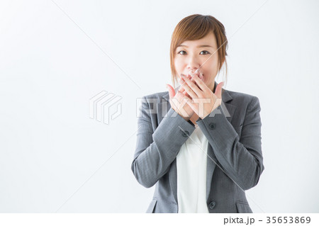 口を隠すビジネスウーマンの写真素材