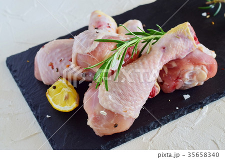 Raw chicken legs on a black slate Raw chicken legs on a black slate 35658340