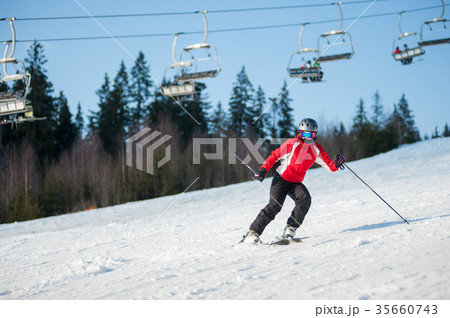 Woman skier with ski at winer resort in sunny day Woman skier with ski at winer resort in sunny day 35660743