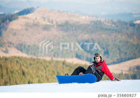 Male boarder on his snowboard at winer resort Male boarder on his snowboard at winer resort 35660827