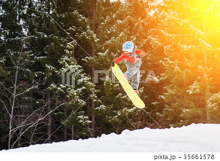 Boy jumping and keeps one hand on the snowboard Boy jumping and keeps one hand on the snowboard 35661578