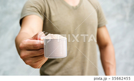 Man holding a whey protein on gray background. Man holding a whey protein on gray background. 35662455