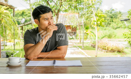 Man writing on a notebook in a cafe. 35662457