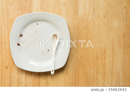 Dirty white plate and spoon with food scrap Dirty white plate and spoon with food scrap 35662642