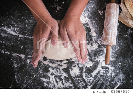 Male hands kneading dough sprinkled with flour table, Hands prep 35667616