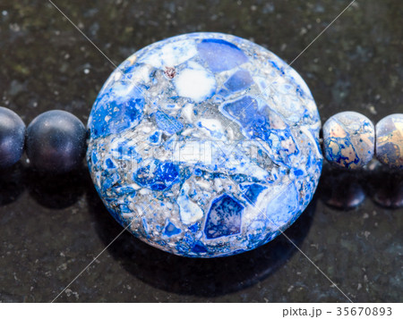 bead from pressed Lazurite stone on dark 35670893